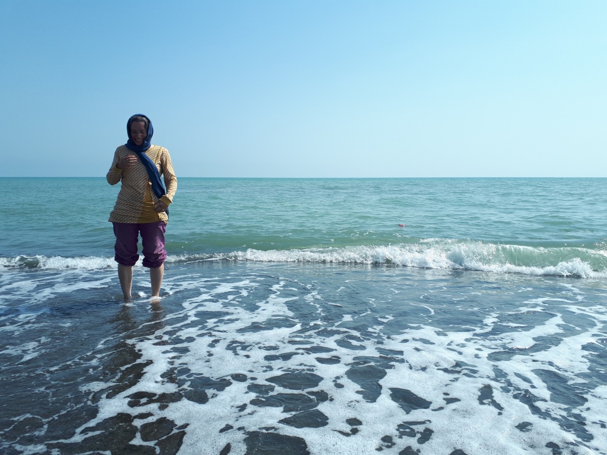 We had such high hopes for riding along the Caspian sea and going for regular swims, but the first 100km of travel was just far enough away and blocked by road meridians so we couldn't see a thing. You'd never know that there was a giant sea just a few hundred meters to the east.
Anyways when we finally saw a road to the beach we hopped on it, and AnSo was first to remove the shoes and get a taste of the water.